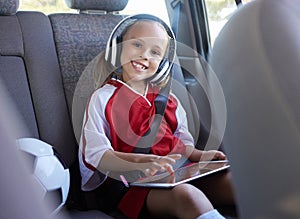 Soccer, car and girl with tablet for music traveling to football practice, exercise and childrens fitness workout. Smile
