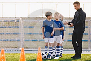 Soccer Coach Motivating Kids on Training. Young Coach With Kids in Soccer Team on Training Unit. Coach on Training with School Boy