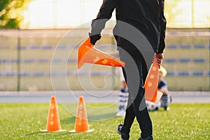 Soccer Coach Preparing Training Field. Trainer Holding Soccer Practice Cones