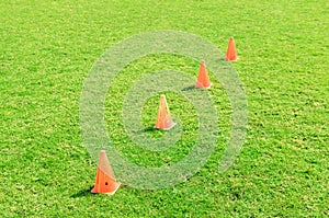 Soccer cone standing on grass.