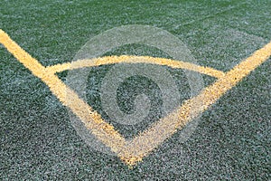 Soccer corner sideline, yellow lines on green artificial turf