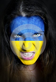 Soccer fan with Ukraine flag painted over face