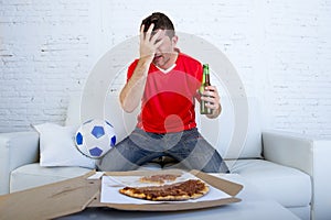 Soccer fan watching football game on TV sad disappointed and desperate