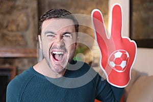 Soccer fan wearing victory sign foam glove