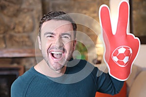 Soccer fan wearing victory sign foam glove