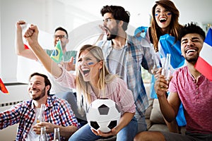 Soccer fans emotionally watching game in the living room.