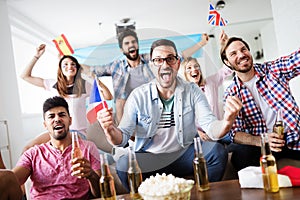 Soccer fans emotionally watching game in the living room.