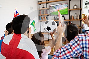 Soccer fans emotionally watching game in the living room.