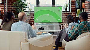 Soccer fans watching football match using greenscreen on television