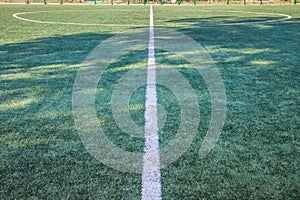 Soccer field with artificial green grass near the school. Amateur football field. Sunny summer day
