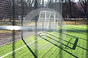 Soccer field behind the fence. Football gates behind the fence