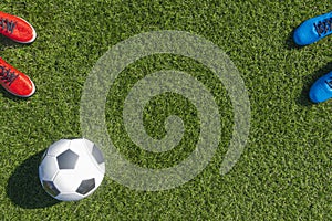 Soccer football background. Soccer ball and two pair of football sports shoes on artificial turf soccer field