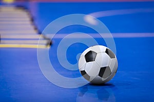 Soccer Football Ball on Futsal Field. Blue Futsal Training Pitch. Training Agility Ladder in the Background