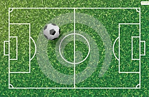 Soccer football ball on green grass of soccer field with line pattern.
