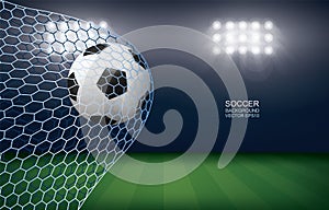 Soccer football ball in soccer goal with soccer field stadium background.