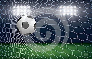 Soccer football ball in soccer goal with soccer field stadium background.