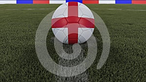 Soccer / football classic ball in the center of the field grass with painting of the England flag with depth of field defocused,