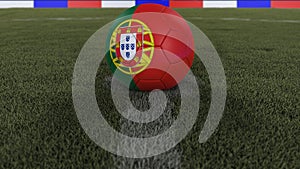 Soccer / football classic ball in the center of the field grass with painting of the Portugal flag with depth of field defocused,