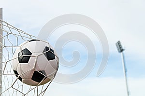 Soccer football in Goal net with the sky field.