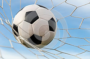 Soccer football in Goal net with the sky field.