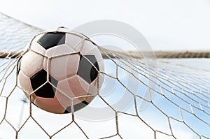 Soccer football in Goal net with the sky field.