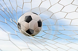 Soccer football in Goal net with the sky field.