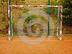 Soccer football net background over green grass and blurry stadium. Close up detail