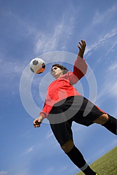Soccer Football Player in red controlling ball