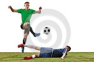 Soccer football players tackling for the ball on grass flooring over white background. Concept of sport, action