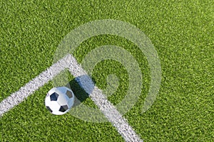 Soccer football sport background. Soccer ball on green artificial grass turf field with white line. Top view