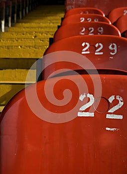 Soccer football stadium seats in red with yellow stairs.