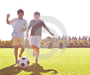 Soccer, friends and happy for playing on grass, support and smiling for sports game on field. Boys, children and