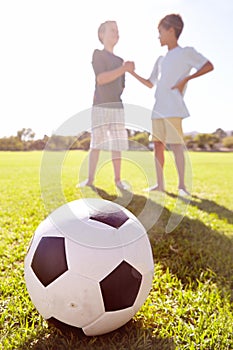 Soccer, friends and team handshake on grass, agreement and partnership on football field. Children, boys and support in