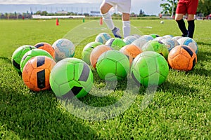 Soccer gears on green grass prepared for training in kids football academy. Popular sport activity