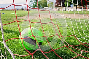 Soccer gears on green grass prepared for training in kids football academy. Popular sport activity