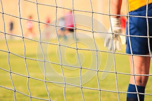 Soccer girl goalkeeper in grass field.