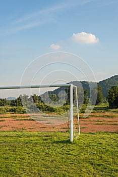 Soccer goal on field with mountain background.