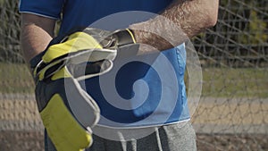 Soccer goalie adjusting goalkeeper gloves outdoors