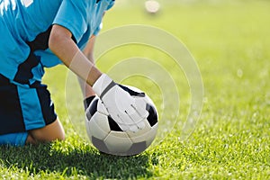 Soccer Goalie With Classic Football Ball. Goalkeeper on Grass Field Holding Ball in Hands