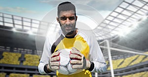 Soccer goalkeeper holding ball near goal