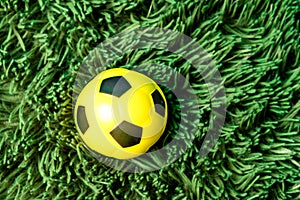 Soccer grass field with ball top view. Soccer ball in fresh green summer or spring field grass