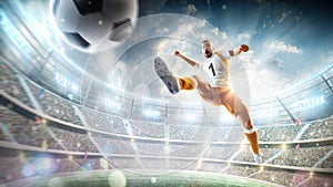 Soccer kick. A soccer player kicks the ball in air fashion. Professional soccer player in action. Stadium with