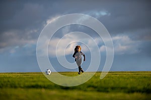 Soccer kid. Kids play football on summer stadium field. Little child boy kicking ball. Football sport training for