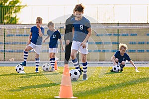 Soccer physical education lesson. Children training football on schools field