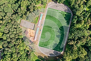 Soccer pitch with amateur football players playing the game in the city park at sunny summer day. aerial view
