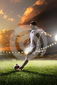 Soccer player in action on sunset stadium background