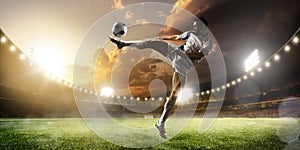 Soccer player in action on sunset stadium panorama background