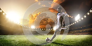 Soccer player in action on sunset stadium panorama background