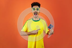 Soccer Player - Black Man Celebrating Holding Solar Photovoltaic Panel Isolated on Orange Background