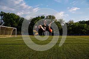 Soccer player celebrating goal on a soccer stadium.Soccer player does a backflip